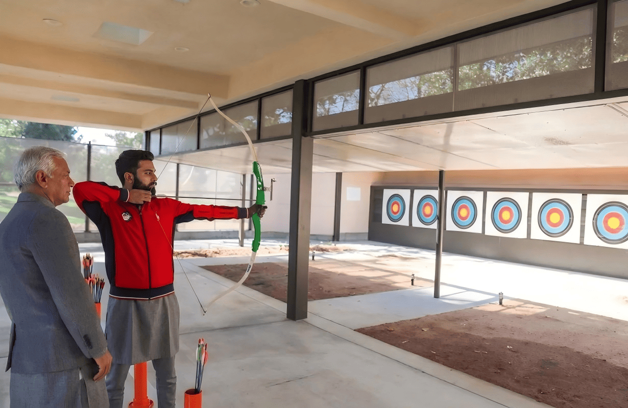 children and adults practicing archery outdoors